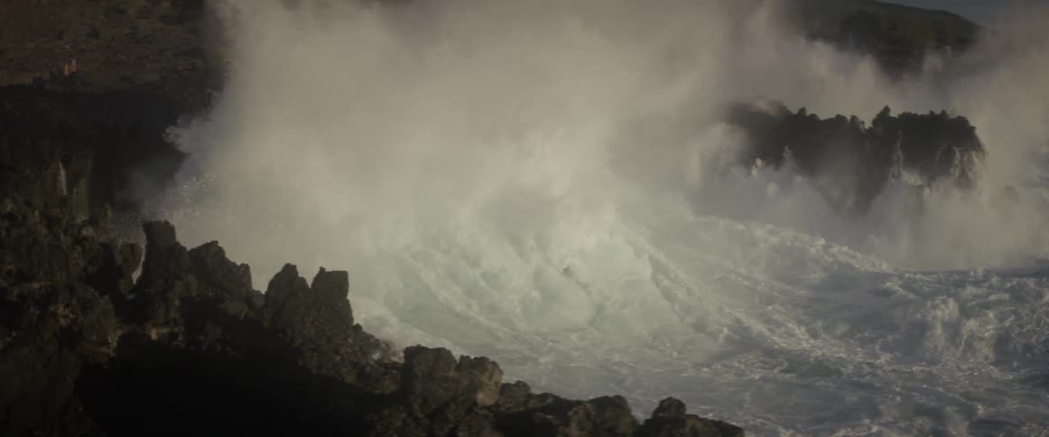Ocean waves crash into a rocky shore