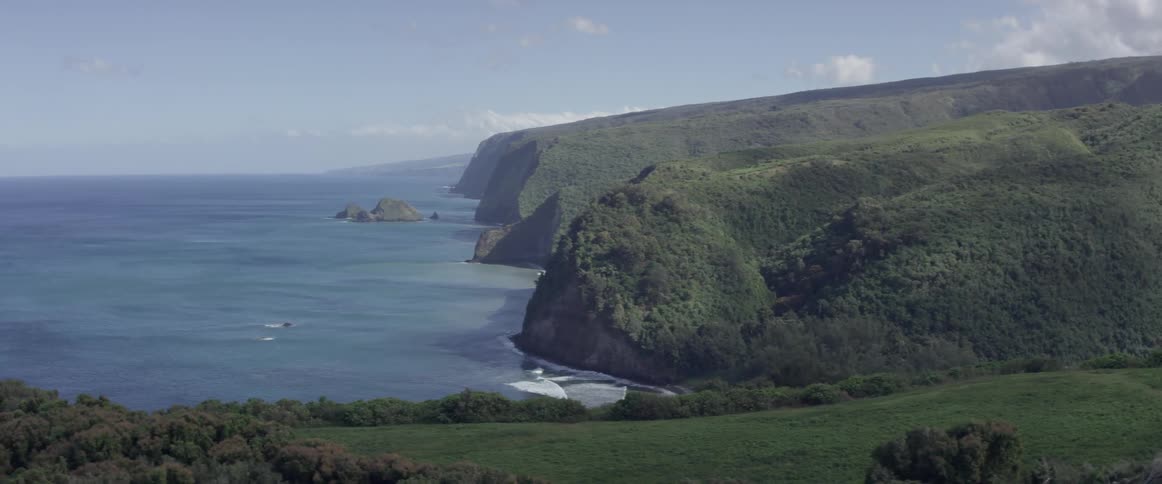 A beach at the base of rolling hills