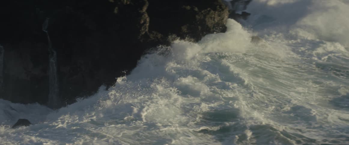 The water is very rough with large waves pushing into the air