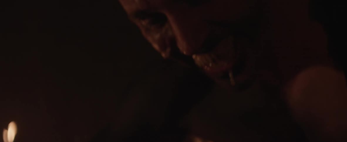 A sharp-toothed man smiles and drools on another man