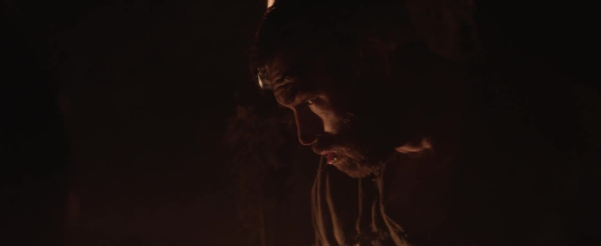 A man is hitting another man inside a cave