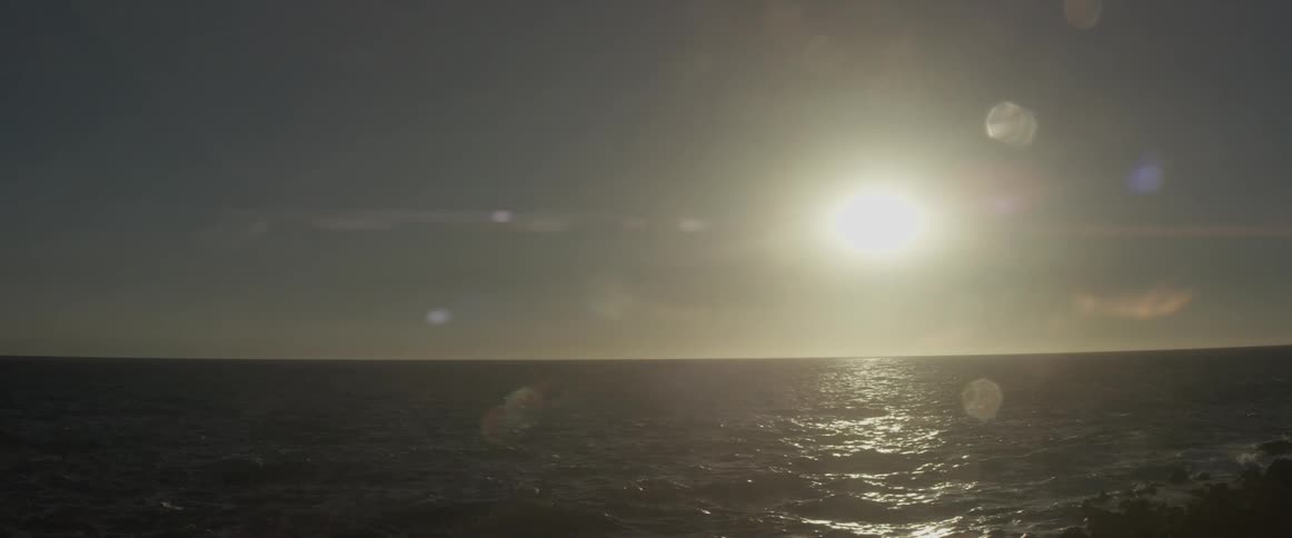 The sun is high over the rough waters