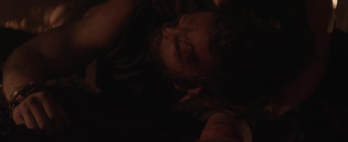 A man is laying on the floor being beaten up