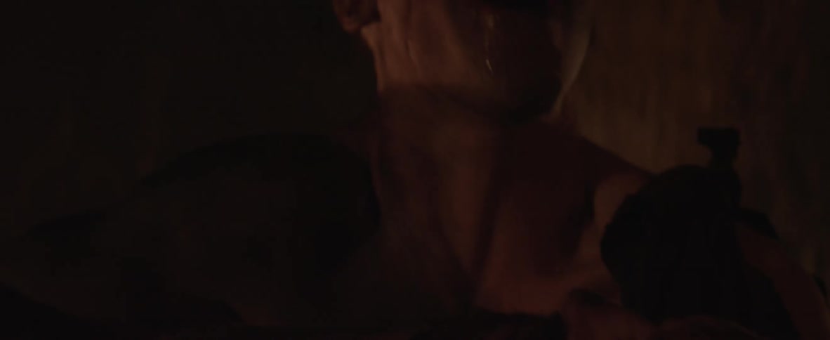 A sharp toothed man laughs while holding a corpse