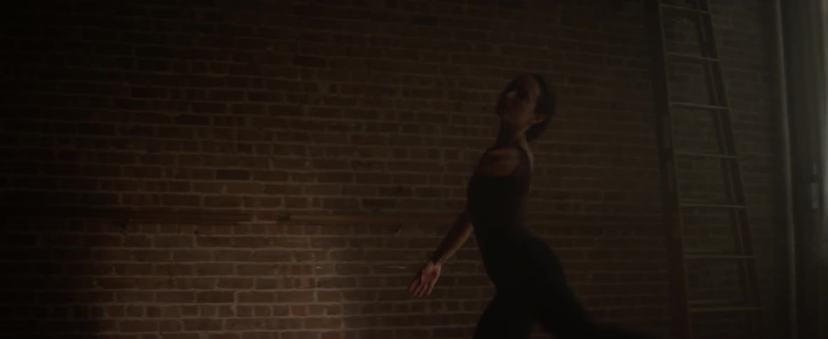 A ballerina leaps in a dance studio