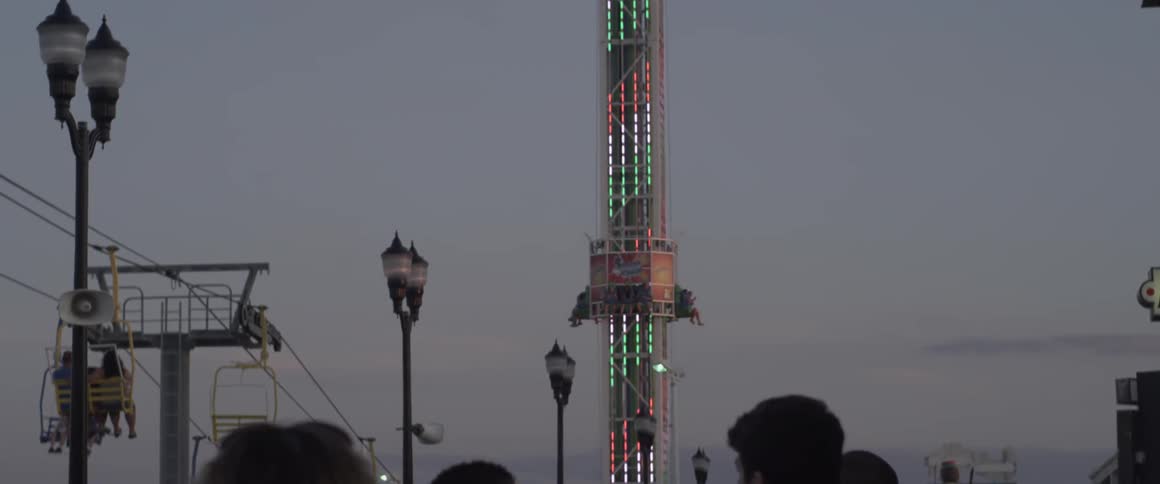 A line for an amusement park ride at sunset