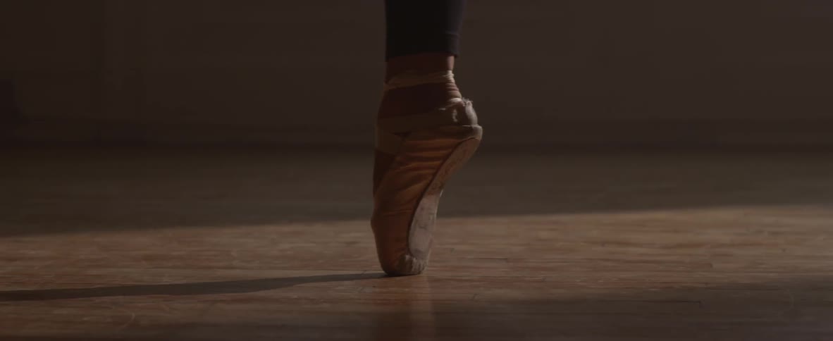 A dancer twirls on the toe of her ballet shoe