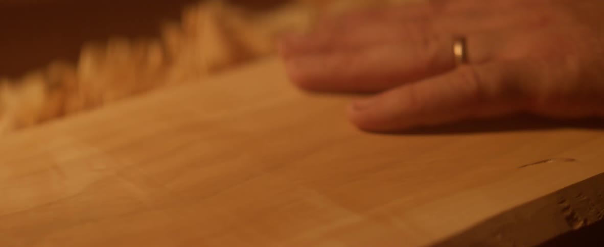 Person rubs their hand over a piece of wood