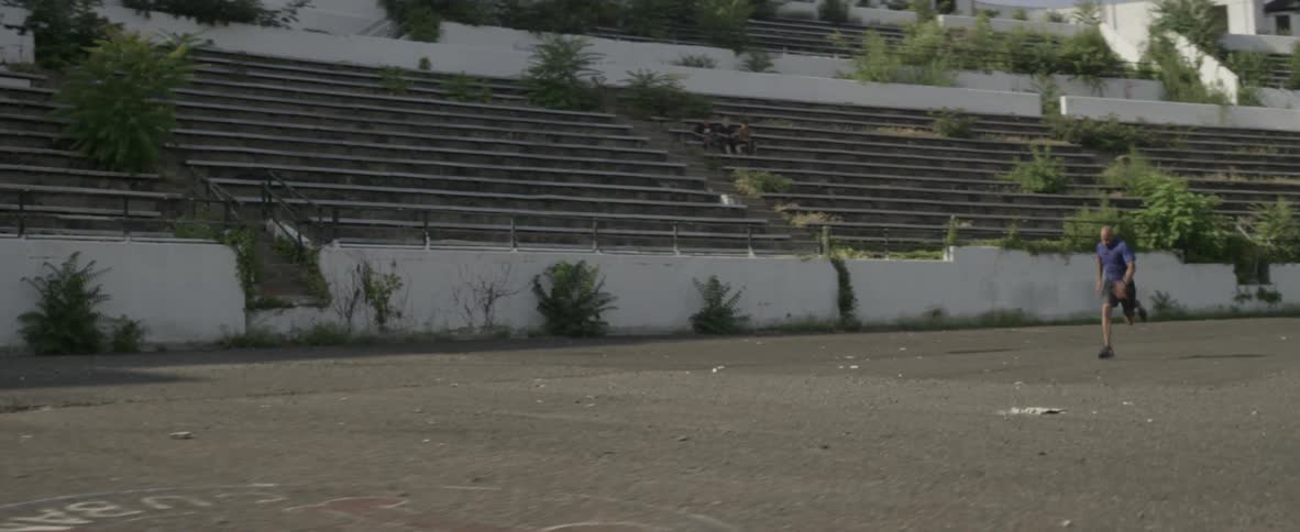 A man runs in an abandoned stadium