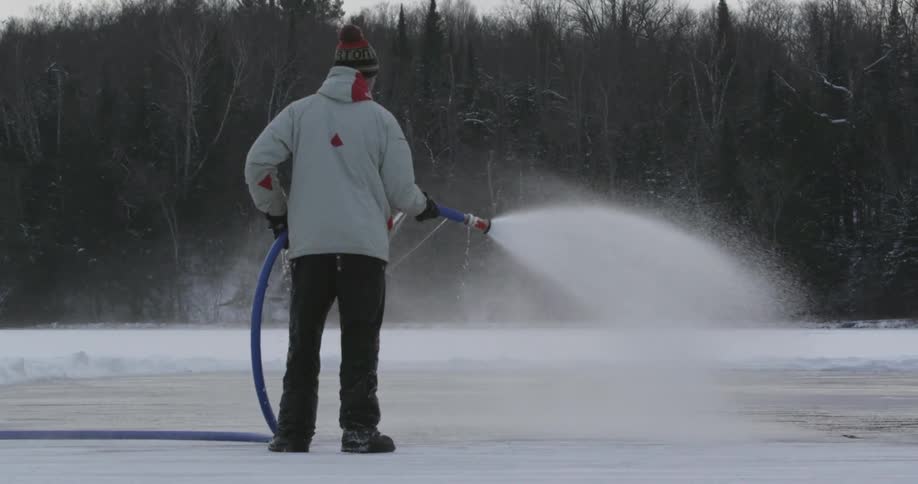 Man spraying water on ice