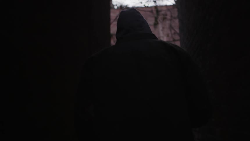 A man walks between city buildings