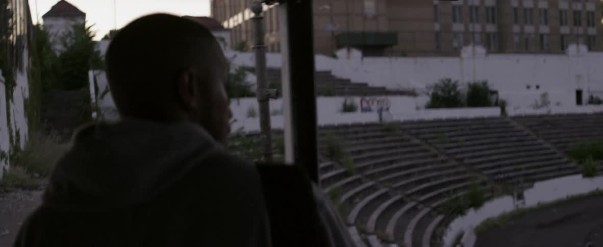 A man in a hoodie walks through a stadium