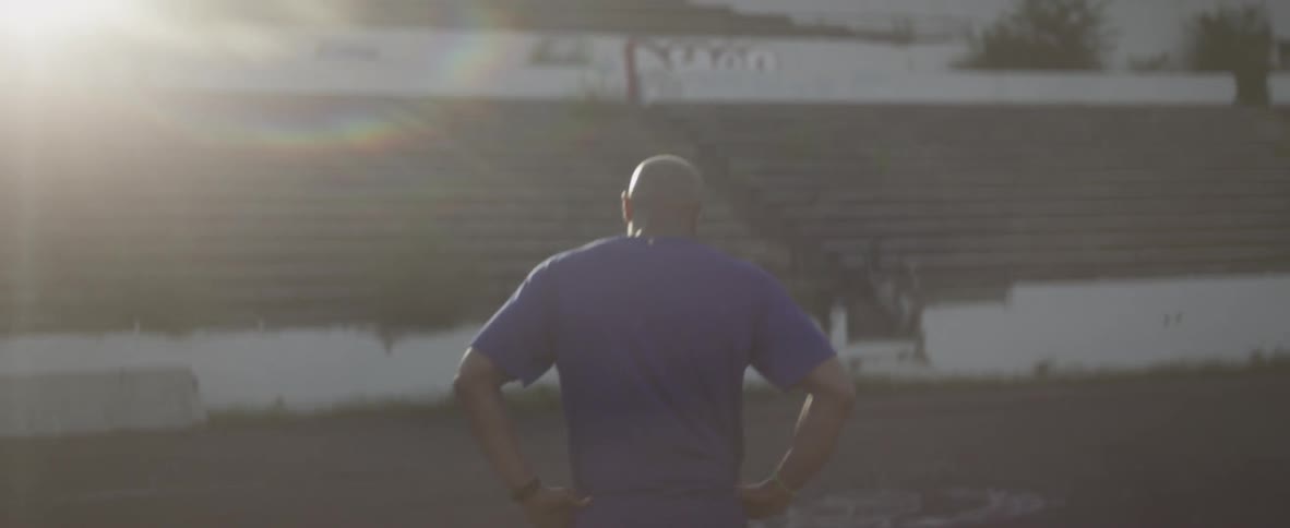 A man walks in an abandoned stadium