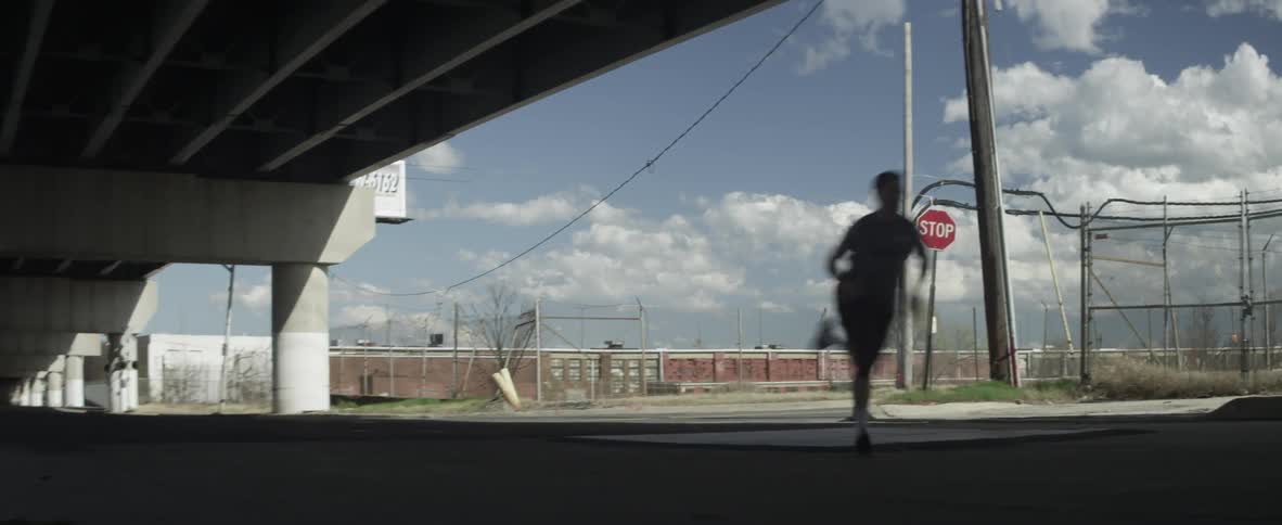 A man runs beneath a city overpass