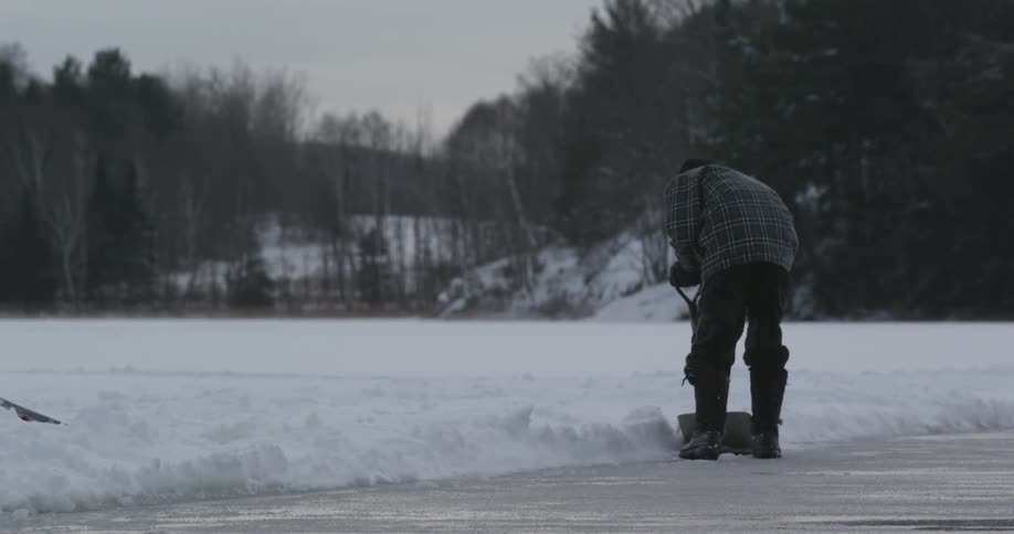 Man shoveling snow off of a driveway