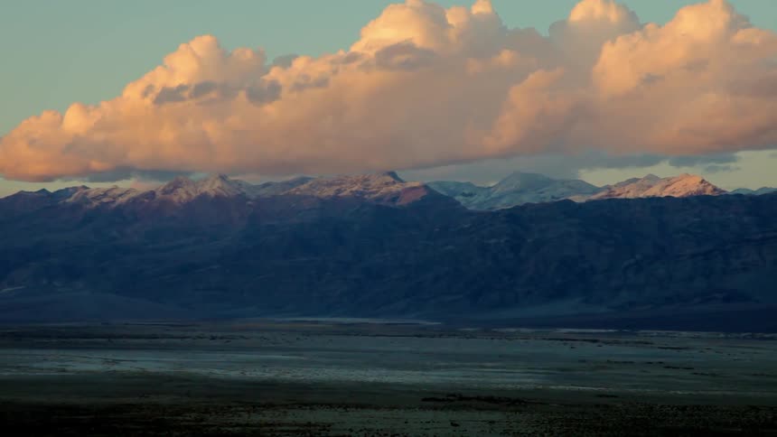 Clouds float over a mountain range at sunset
