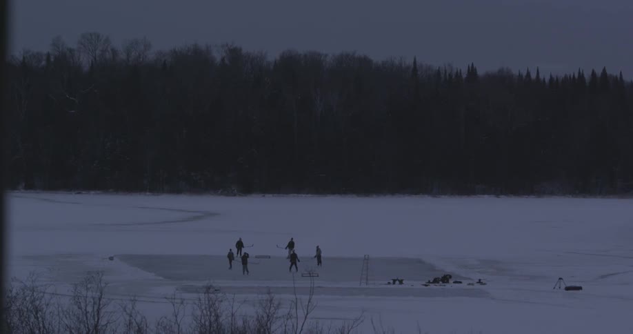 People playing hockey on a lake
