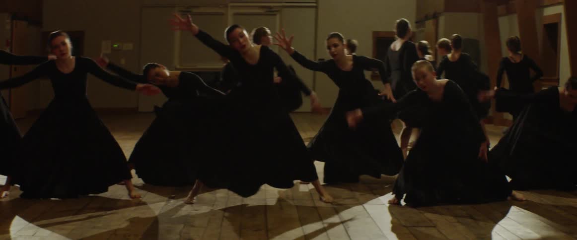 Women in black dresses performing dance moves