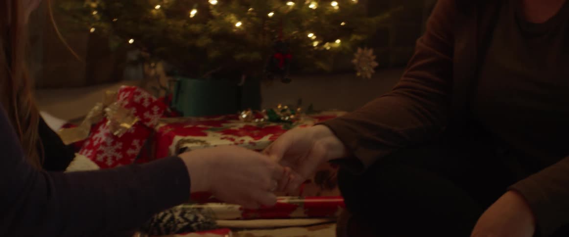 Two women talk as they wrap gifts