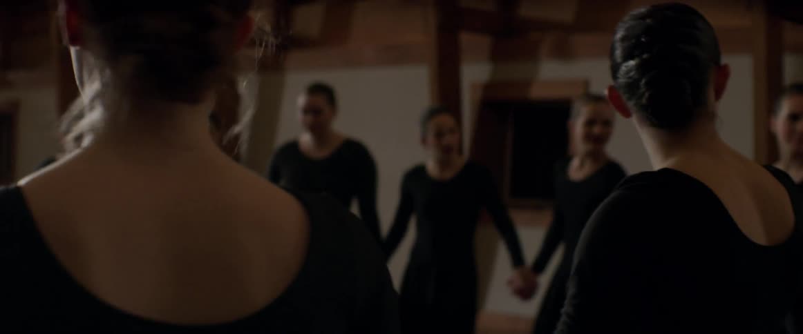 A dance team joins hands in a circle