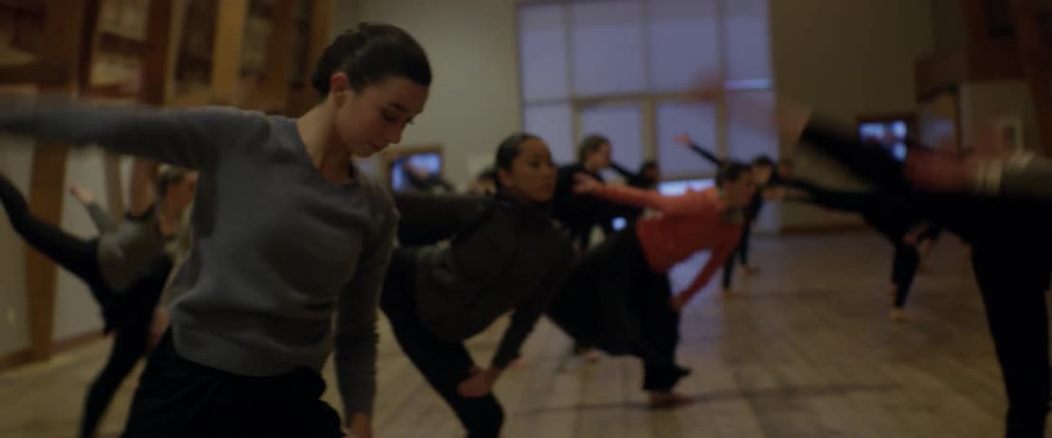 People dancing in unison in a dance studio