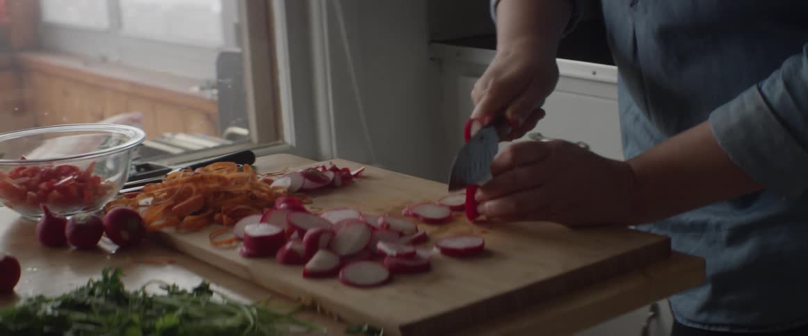 A person is cutting food on a board