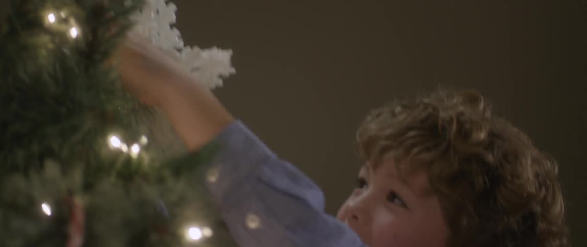Smiling child decorating a christmas tree