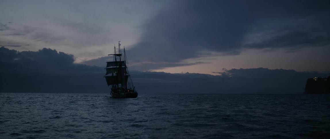 Ship sails in the ocean at sunset