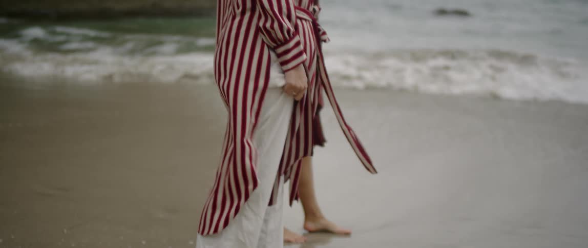 Two people stand together on the beach