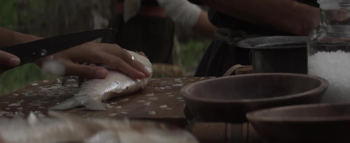 Scales are removed from a fish with a knife