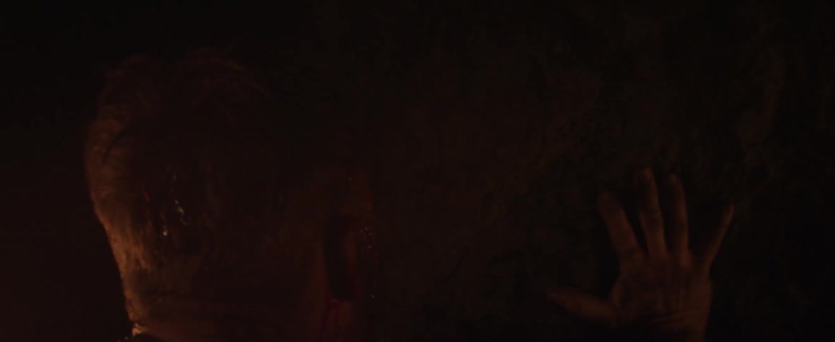A person searches around in a dark cave
