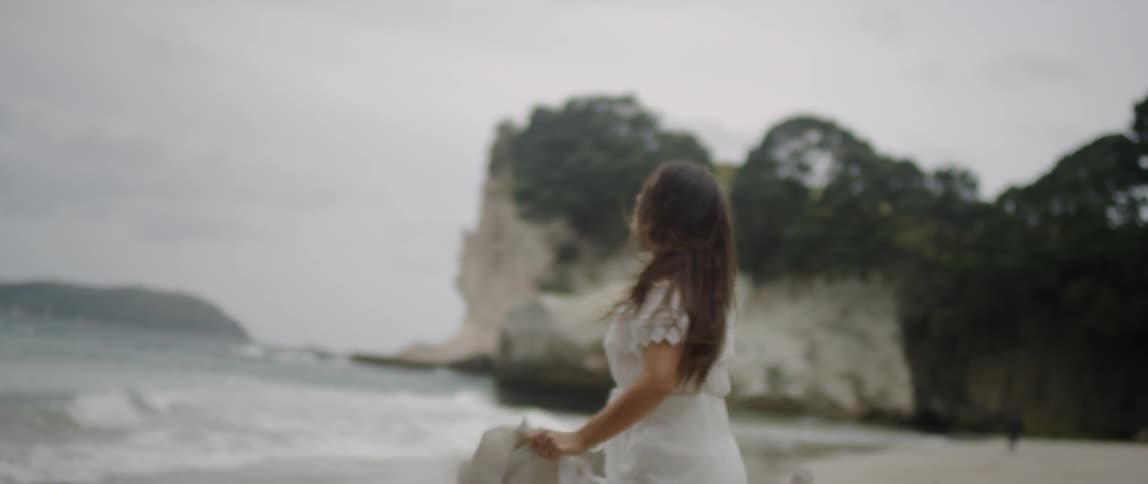 A woman runs towards the beach