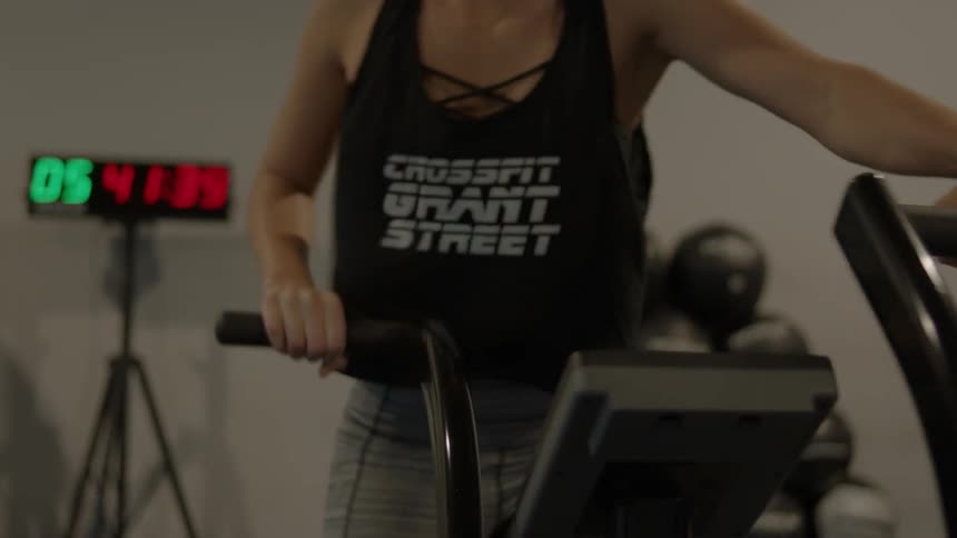 A woman exercises using a machine at a gym