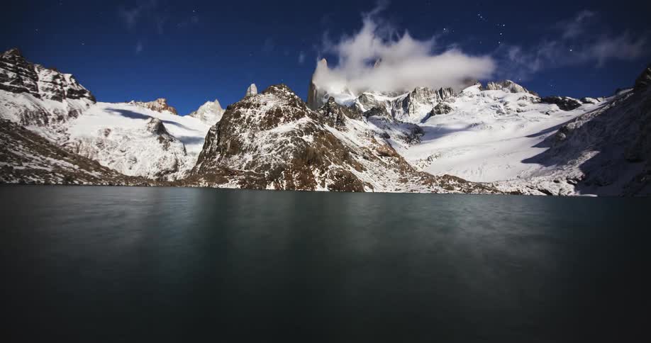 Clouds pass above a frozen mountain lake