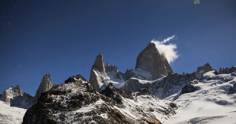 Clouds move past the mountain covered with ice