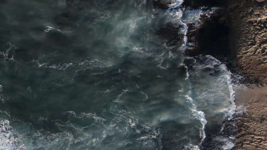 Ocean waves wash ashore a rocky beach