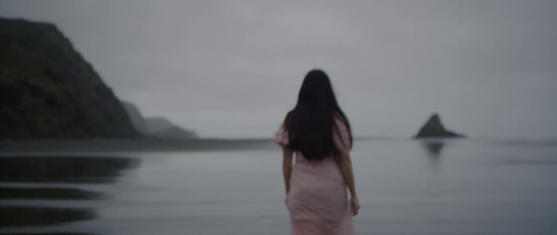 A woman walks on a sandy beach