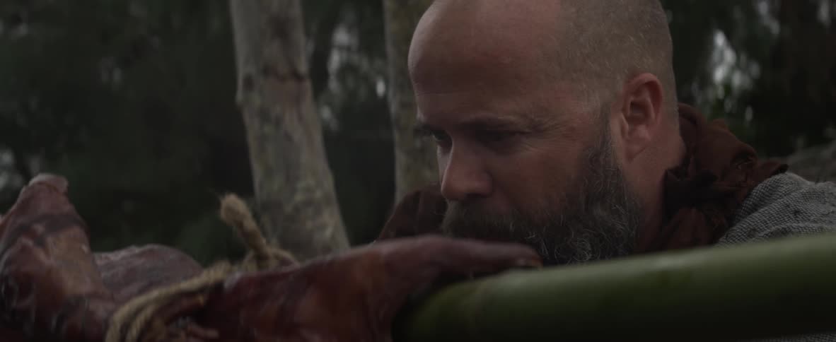 A man with a bird is chewing on something