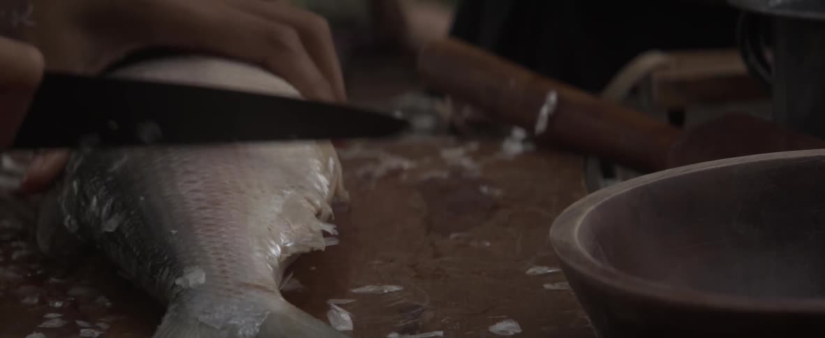 A chef fillets a fish