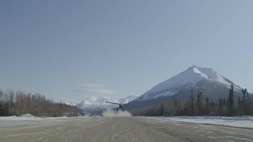 Plane taking off with mountain in background