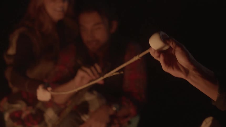 People roast marshmallows in a campfire