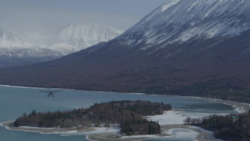 A plane soars over a lake