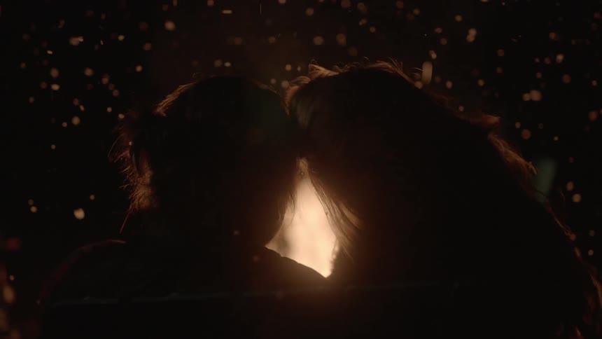 A couple sitting by a fire
