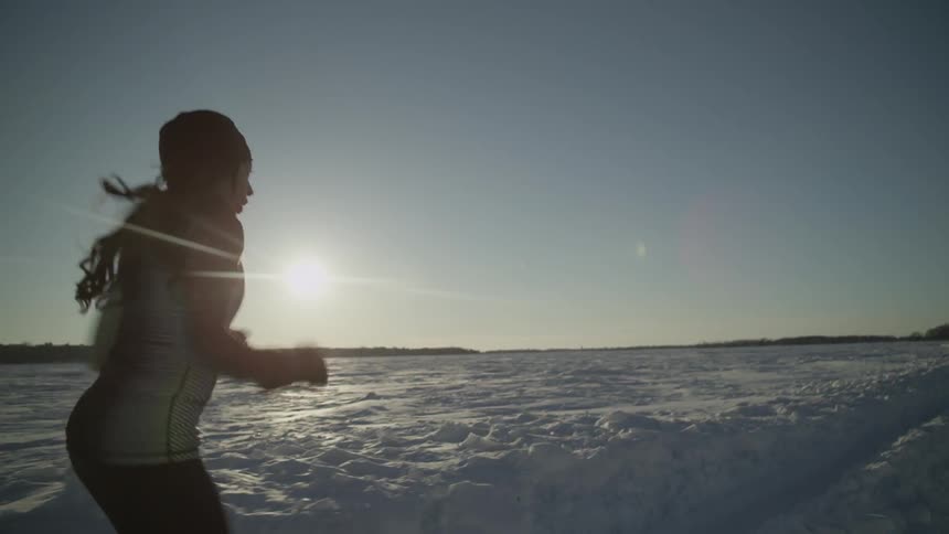 A woman jogs in a snowy field