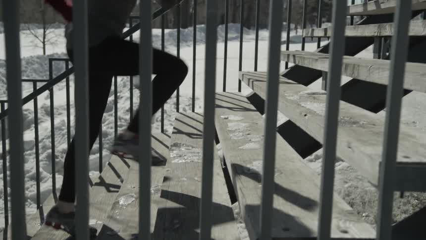 A woman is running up stairs in the winter