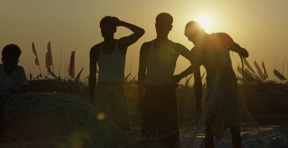 Three kids are gathering up fishing nets