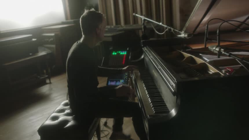 One man is playing the drums and the other man is playing piano