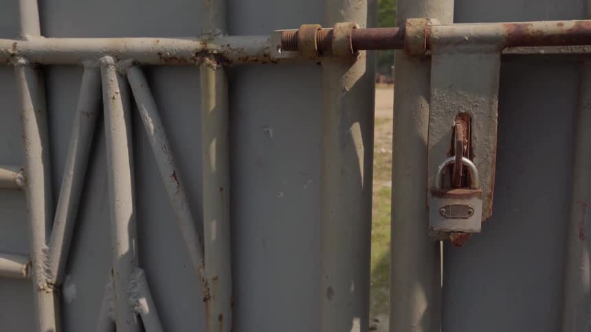 A bit of grass is visible behind a locked gate