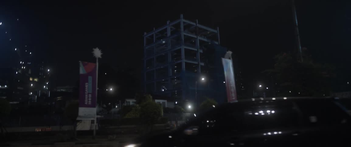 Cars drive on a city street at night