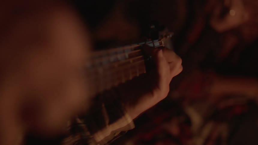 A guitar is played outside at night